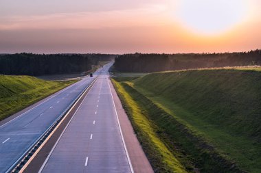 Ülke karayolu ve günbatımı. Açık yol büyük doğa çevresinde