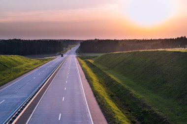 Ülke karayolu ve günbatımı. Açık yol büyük doğa çevresinde