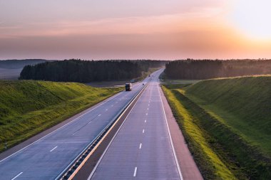 Ülke karayolu ve günbatımı. Açık yol büyük doğa çevresinde
