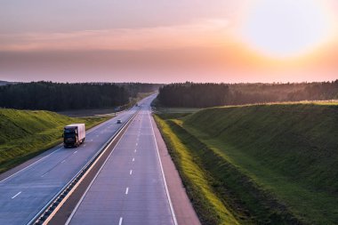 Ülke karayolu ve günbatımı. Açık yol büyük doğa çevresinde