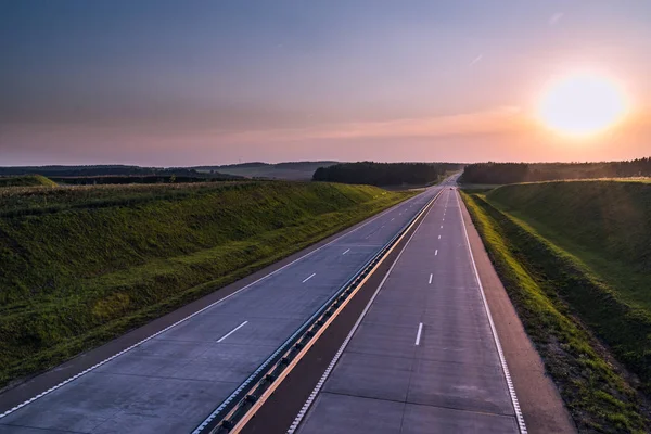 Ülke karayolu ve günbatımı. Açık yol büyük doğa çevresinde