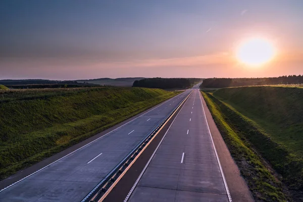 Ülke karayolu ve günbatımı. Açık yol büyük doğa çevresinde