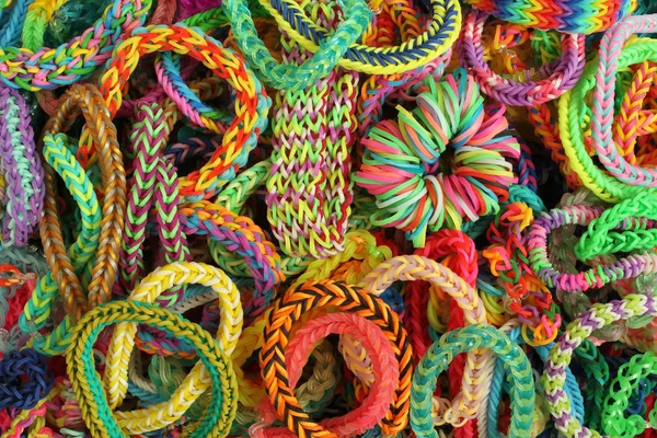 Contexte - divers types de bracelets colorés, tressés en caoutchouc — Photo