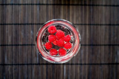 Saydam bir cam köpüklü frambuazlı limonata su