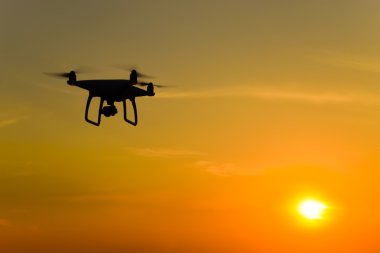 Quadrocopters siluet güneşin arka planı. Akşam gökyüzünde uçan uçaklar