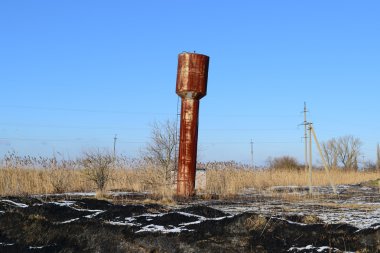 Eski paslı su kulesi eğilmiş. Eski bir rustik ortak iletişim.
