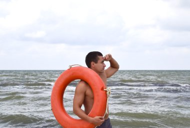 Adam bir lifebuoy ile sahilde