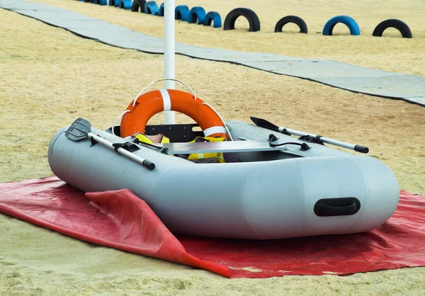 Bote de rescate inflable. Barco inflable gris en la playa en la arena —  Fotos de Stock