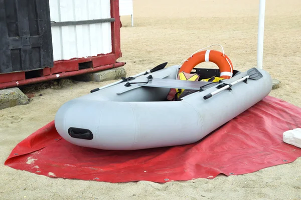 Bote de rescate inflable. Barco inflable gris en la playa en la arena —  Fotos de Stock