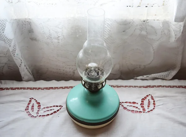 Lámpara de queroseno en la mesa cerca de la ventana — Foto de Stock