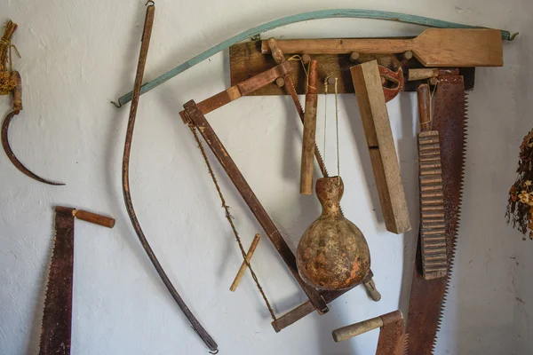 Herramientas vintage en la pared. Sierras, hachas, hoz y otros instrumentos de época —  Fotos de Stock