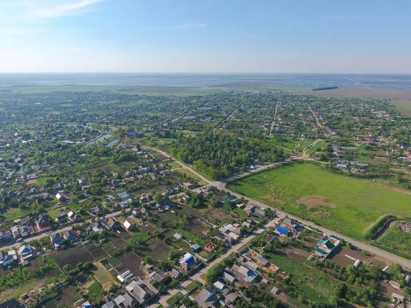 Top view of the village. One can see the roofs of the houses and gardens. Road and water in the village. Village bird's-eye view