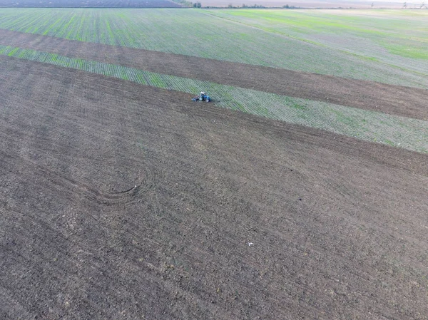 Bovenaanzicht van de trekker die plows van het veld. disking van de bodem. Grondbewerking na de oogst — Stockfoto