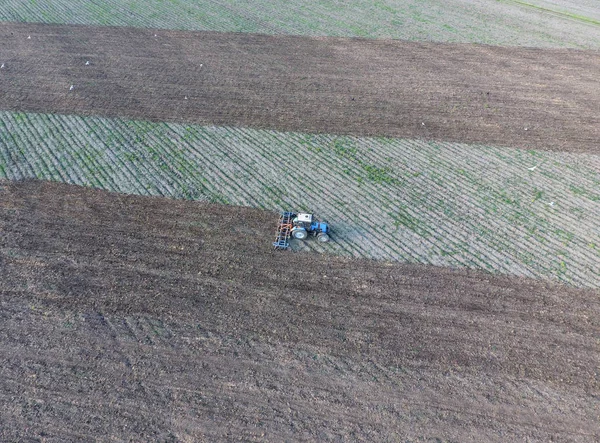Vista superior do trator que arado o campo. a dissecar o solo. Cultivo do solo após a colheita — Fotografia de Stock