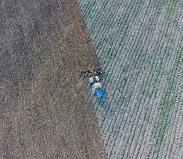 Вид сверху на трактор, который вспахивает поле. дисков почвы. Обработка почвы после сбора урожая — стоковое фото