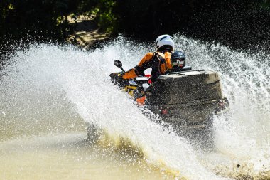 ATV 'deki adam dereyi geçiyor. Turist ülkeyi boydan boya geziyor.