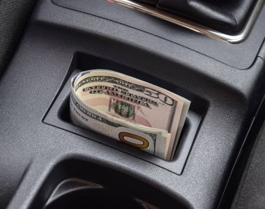 Birkaç banknot Amerikan Doları arabanın Merkezi Konsol niş içinde yalan. Para arabada