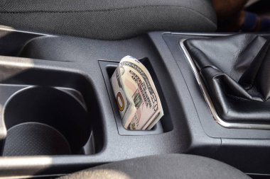 Birkaç banknot Amerikan Doları arabanın Merkezi Konsol niş içinde yalan. Para arabada