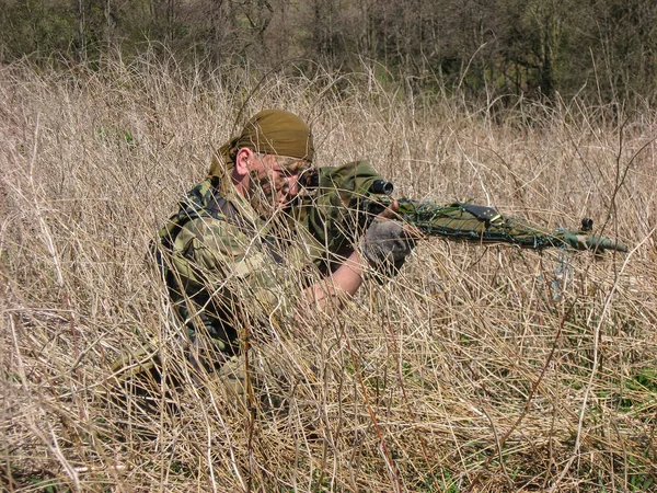 Lutador de tropas especiais. rifle atirador Dragunov escondido na grama seca, e apontando para um alvo — Fotografia de Stock