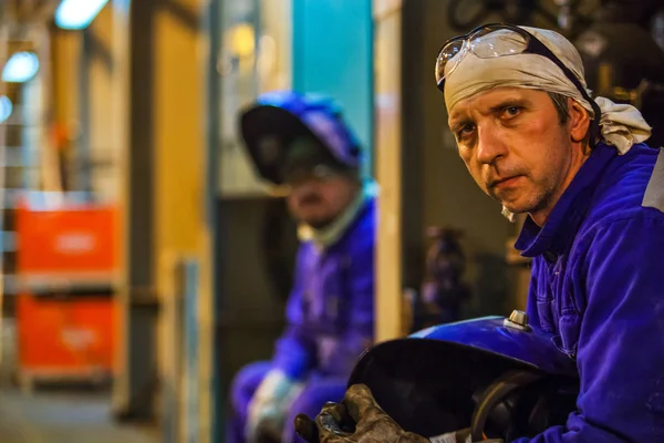 Travailleurs monteurs et soudeurs en vêtements de protection et un casque. Travailler dans les installations industrielles en exploitation — Photo