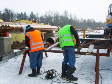İş güvenliği. Kaynak ve demir kurguları taşlama. Endüstriyel hafta içi kaynakçılar ve tesisatçıları