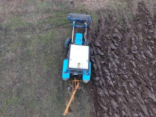 Traktor membajak taman. Membajak tanah di kebun — Stok Foto