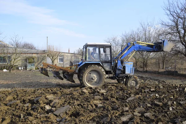 Tractor plowing the garden. Plowing the soil in the garden.