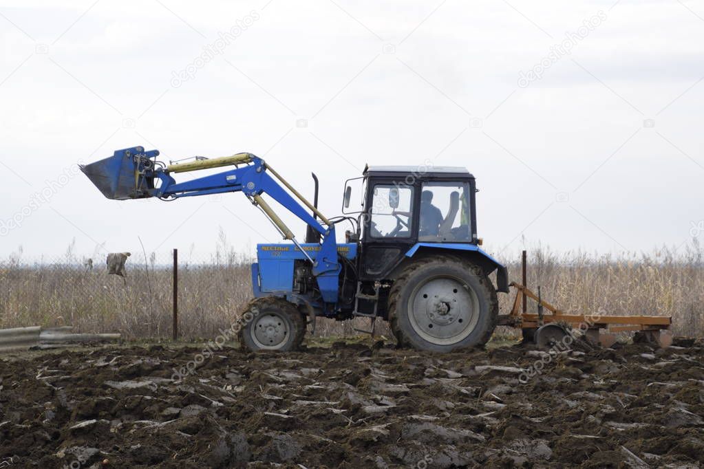 Tractor plowing the garden. Plowing the soil in the garden.