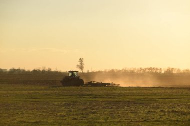 Traktör günbatımı Saban, pulluk bir alan. Hasat sonra sonbaharda toprak tilling. Sezon sonunda.