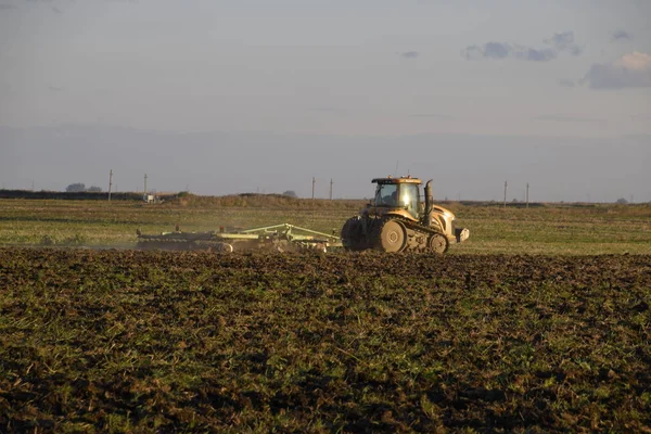 Traktor membajak lahan. Tilling tanah di musim gugur setelah panen. Akhir musim ini — Stok Foto