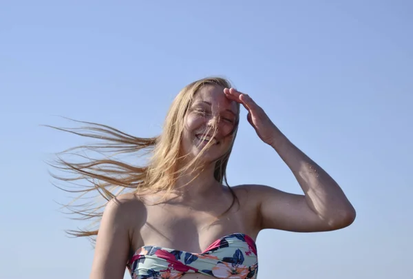 Блондинка с голубыми волосами на фоне неба. Красивая молодая женщина в красочном бикини — стоковое фото