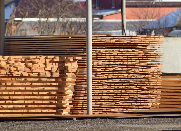 Baustofflager, Holzbohlen unter einem Baldachin gestapelt — Stockfoto