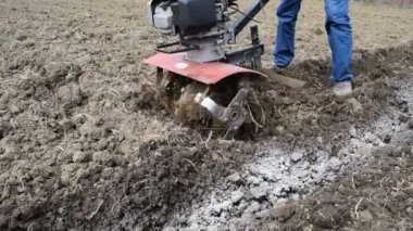 Arkadaki traktörün altına patates ekiyorum. Bahçede motor bloğu olan bir adam..
