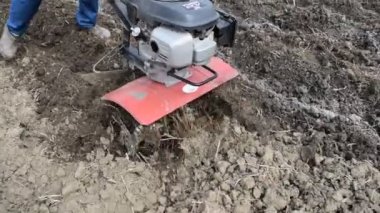 Arkadaki traktörün altına patates ekiyorum. Bahçede motor bloğu olan bir adam..