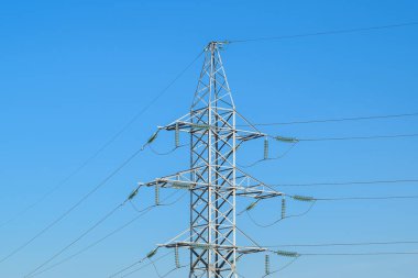 Yüksek voltajlı elektrik hatları mavi gökyüzü destekler