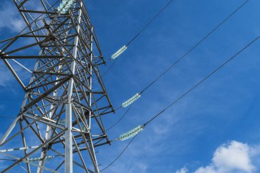 Yüksek voltajlı elektrik hatları mavi gökyüzü bulutlu destekler. Elektrik Sanayi