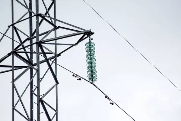 Glass prefabricated high voltage insulators on poles high-voltage power lines. Electrical industry — Stock Photo, Image