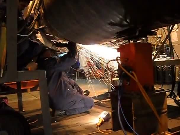 Cleaning a welding connection using grinders. Flying sparks. Welding underwater pipeline. — Stock Video