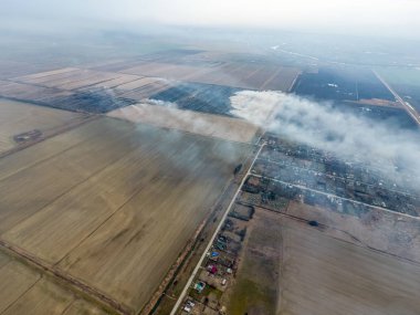 Yukarıdan küçük bir köy. Duman saman yakma üzerinden köyün yayılır