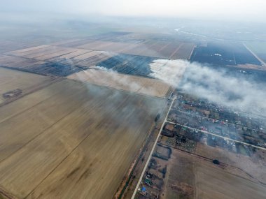 Yukarıdan küçük bir köy. Duman saman yakma üzerinden köyün yayılır