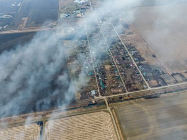 Yukarıdan küçük bir köy. Duman saman yakma üzerinden köyün yayılır