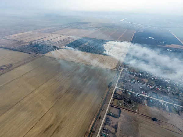 Yukarıdan küçük bir köy. Duman saman yakma üzerinden köyün yayılır