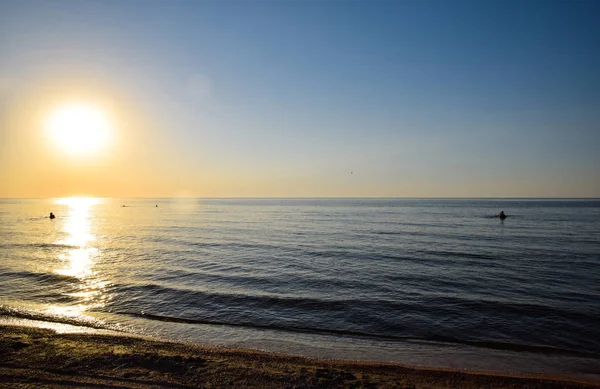 Sea sunset. People bathe in the evening at sunset in the sea