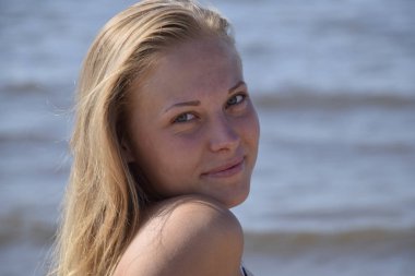 Deniz suyu bir arka plan üzerinde kız sarışın. Güzel genç kadın.