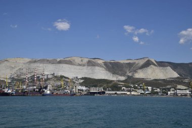 Uluslararası liman. Kargo bağlantı noktası bağlantı noktası ile vinç. Deniz defne ve dağlık sahil.