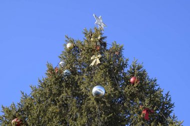 Süslemeleri yılbaşı ağacı. Tinsel ve oyuncaklar, topları ve diğer süslemeleri Noel Noel ayakta açık havada ağaç.