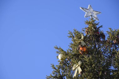 Süslemeleri yılbaşı ağacı. Tinsel ve oyuncaklar, topları ve diğer süslemeleri Noel Noel ayakta açık havada ağaç.