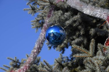 Süslemeleri yılbaşı ağacı. Tinsel ve oyuncaklar, topları ve diğer süslemeleri Noel Noel ayakta açık havada ağaç.