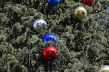 Süslemeleri yılbaşı ağacı. Tinsel ve oyuncaklar, topları ve diğer süslemeleri Noel Noel ayakta açık havada ağaç.