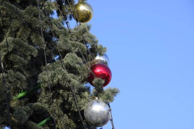 Süslemeleri yılbaşı ağacı. Tinsel ve oyuncaklar, topları ve diğer süslemeleri Noel Noel ayakta açık havada ağaç.